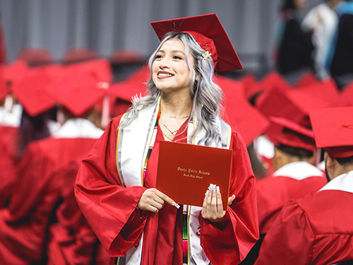 A student shows off her diploma
